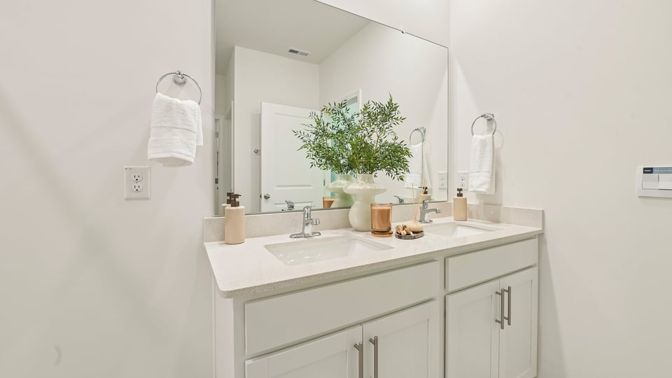 primary bathroom with walk in shower and dual vanity sinks