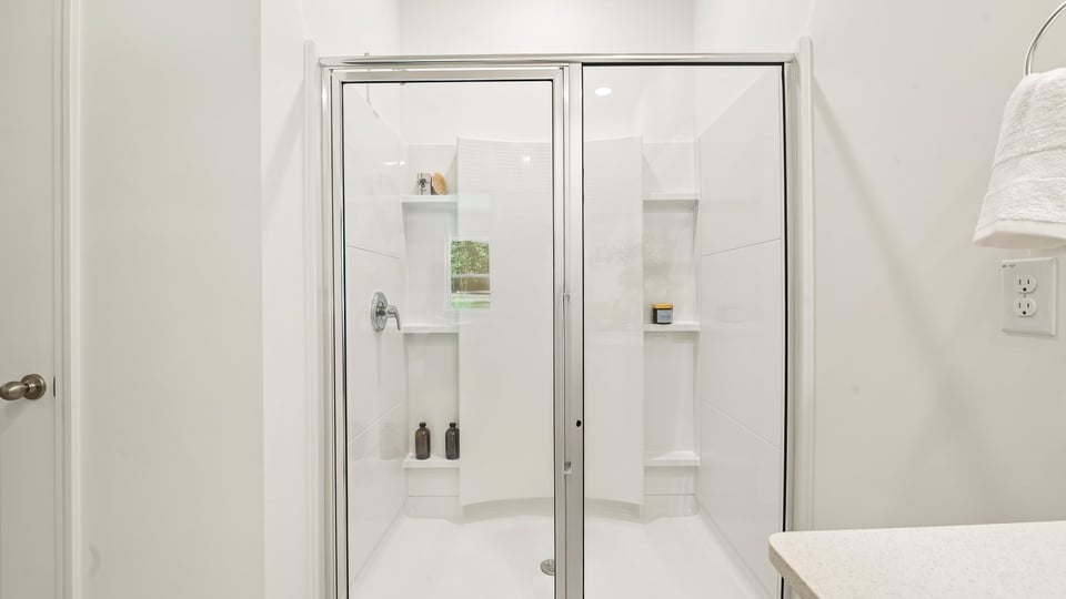 primary bathroom with walk in shower and dual vanity sinks