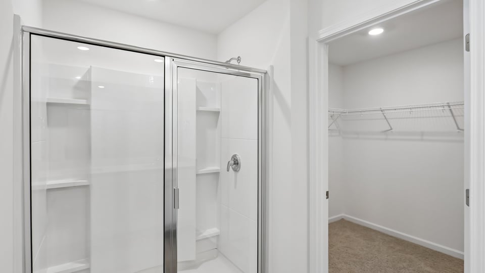 primary bathroom with walk in shower and dual vanity sinks