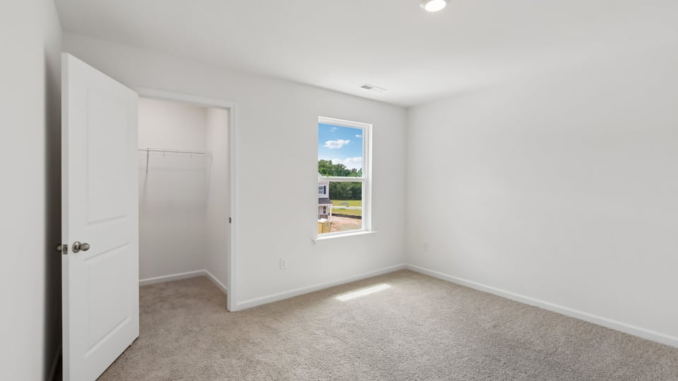 secondary bedroom with window and closet, carpeting