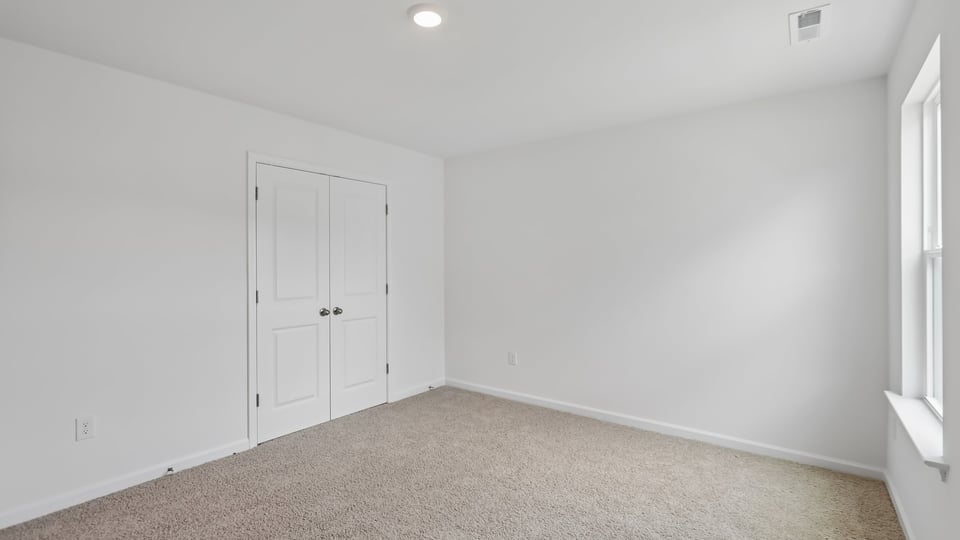 additional bedroom with window, carpeting, closet