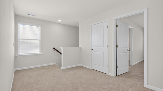 upstairs loft area with large windows and carpeting