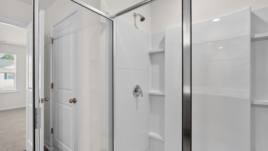 primary bathroom with walk in shower and dual vanity sinks