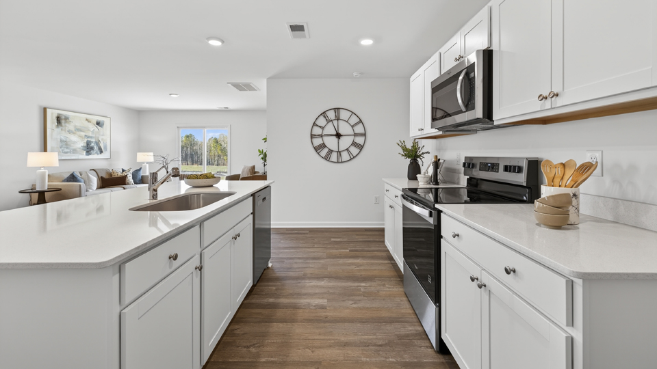 kitchen with quartz counters, kitchen island, pantry, stainless steel appliances