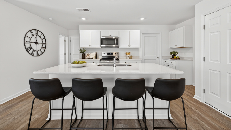 kitchen with quartz counters, kitchen island, pantry, stainless steel appliances
