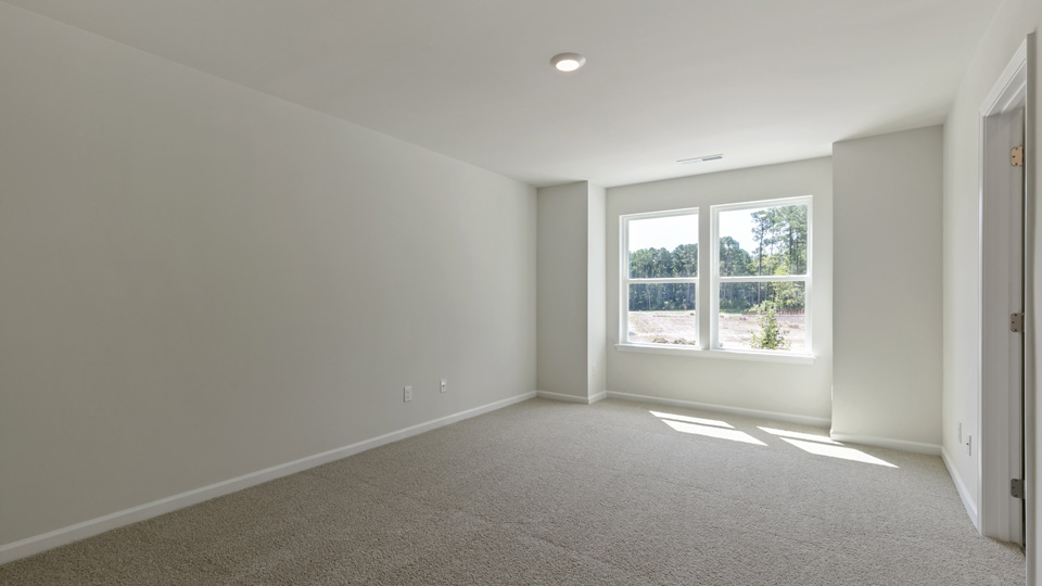 Primary bedroom with carpet flooring and windows