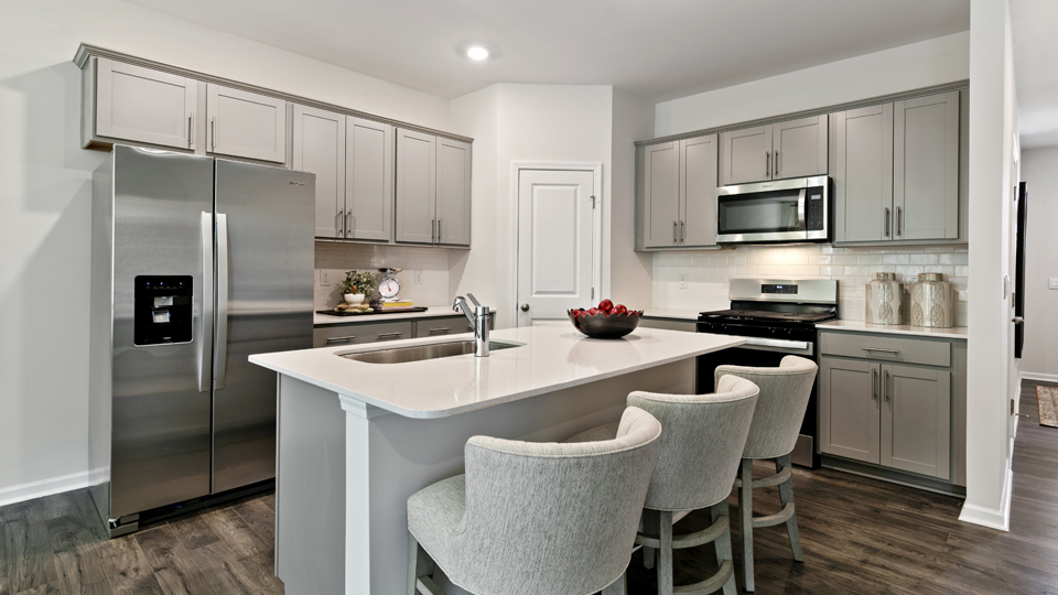 kitchen with stainless steel appliances, quartz counters, gray cabinets