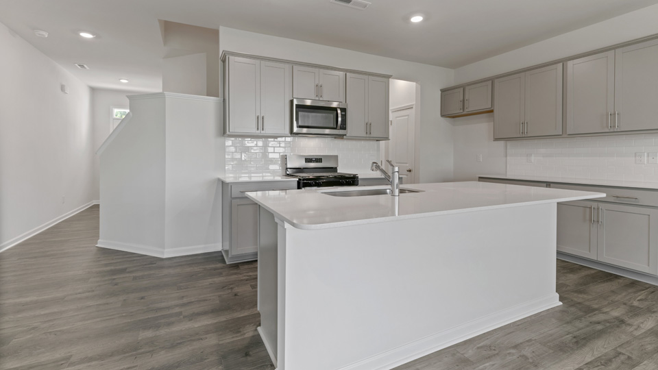 kitchen with gray cabinets, white quartz counters, stainless steel appliances, lvp floor