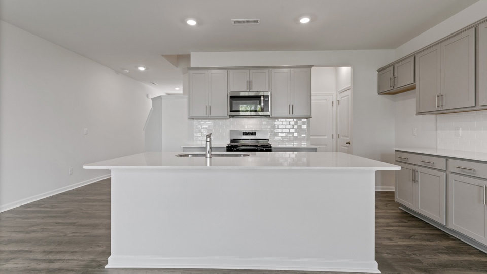 kitchen with gray cabinets, white quartz counters, stainless steel appliances, lvp floor