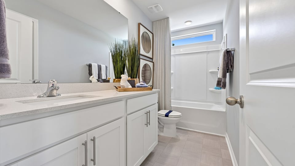 bathroom with white cabinets quartz countertops and tub shower combo