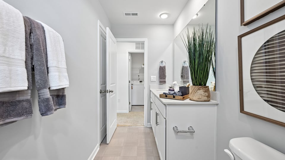 bathroom with dual vanity and white cabinets