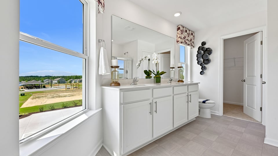primary bathroom with dual vanity and quartz countertops