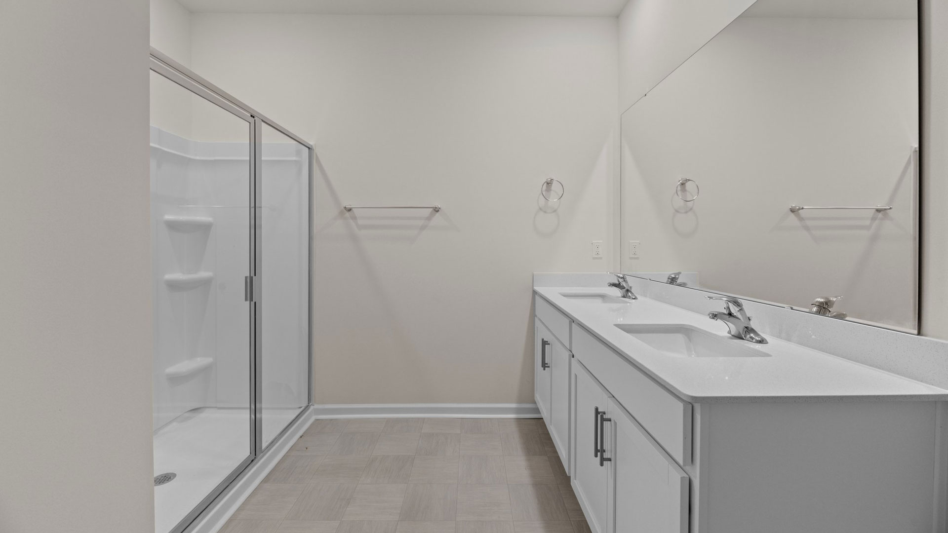 bathroom with walkin shower and dual vanity with quartz countertops