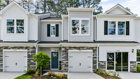 Front exterior of a Denver floorplan home featuring white and grey siding with stone accents