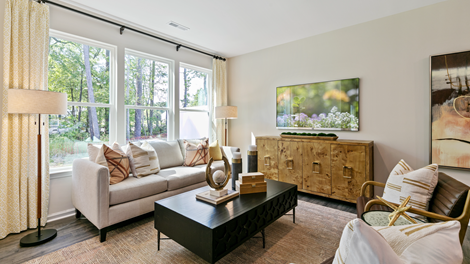 living room featuring beige sofa, 2 accent chairs and brown and green decor