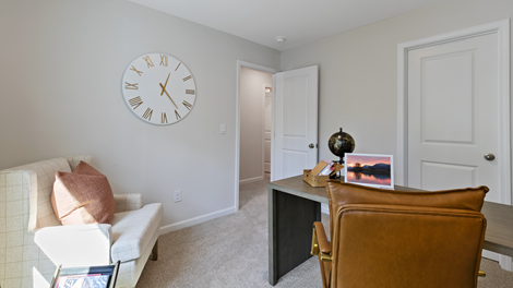 bedroom turned into a home office with grey wallpaper and orange accent decor