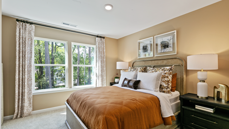 bedroom featuring a bed with orange bedding and neutral decor