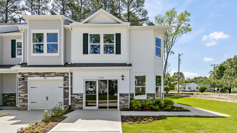 Front exterior view of the home featuring white siding, stone accents and black shutters