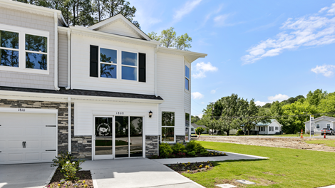 Front exterior view of the home featuring white siding, stone accents and black shutters