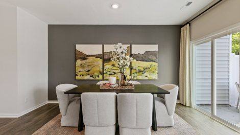 formal dining room featuring a table and green paintings