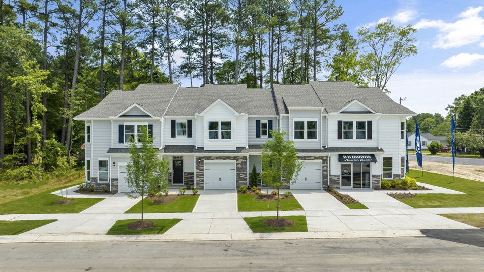 front exterior of four townhomes featuring driveway and garage door