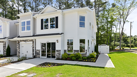 Front exterior view of the home featuring white siding, stone accents and black shutters
