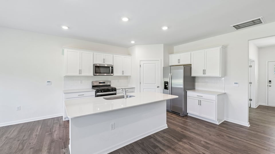 kitchen with white cabinets spacious island and quartz countertops