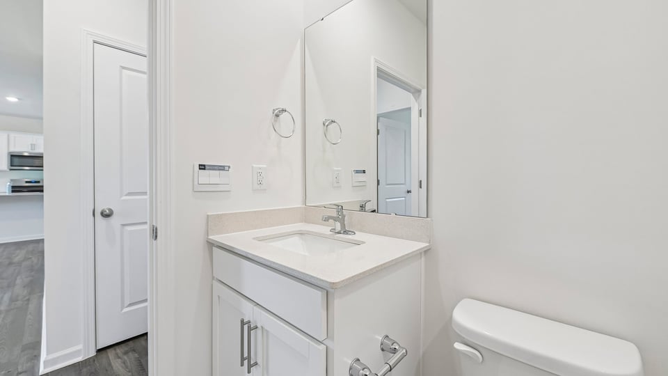 bathroom with white cabinets and quartz countertops