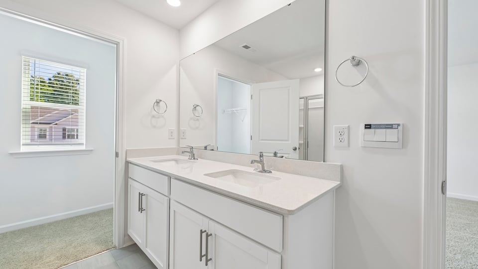 bathroom with white cabinets and dual vanity