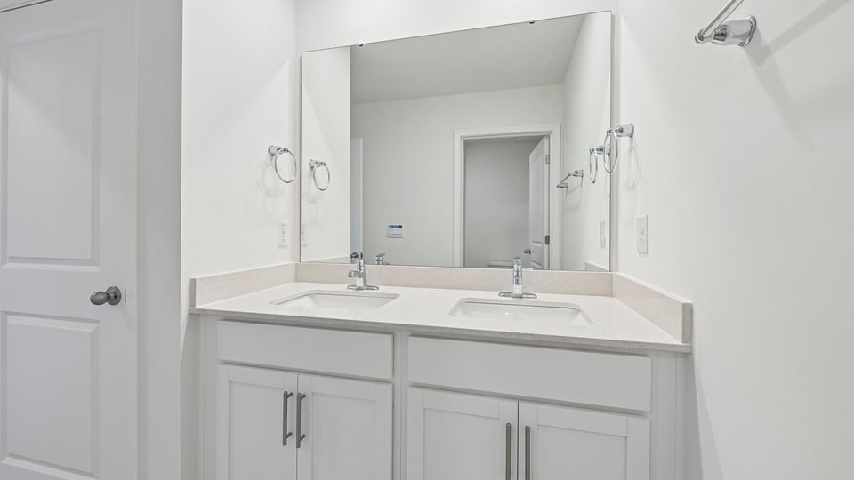 bathroom with dual vanity sinks and quartz countertops