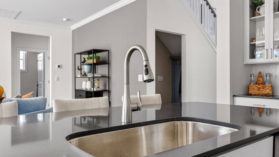 kitchen with quartz counters, kitchen island, pantry, stainless steel appliances