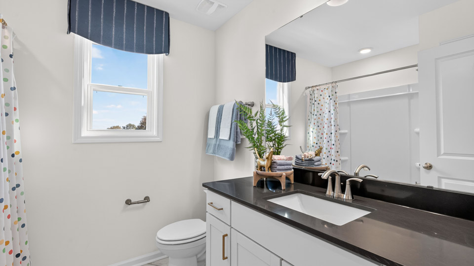 bathroom with quartz countertops and white cabinets