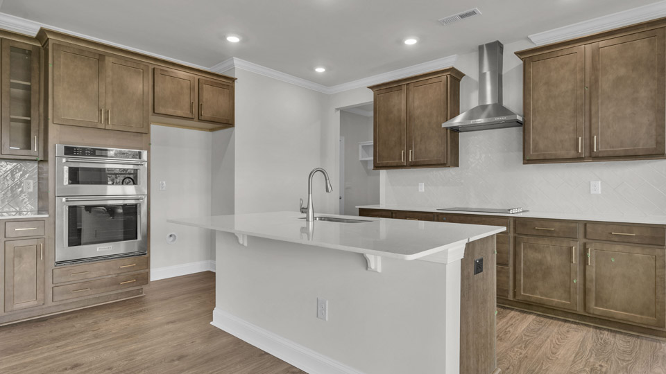 kitchen with quartz counters, kitchen island, pantry, stainless steel appliances
