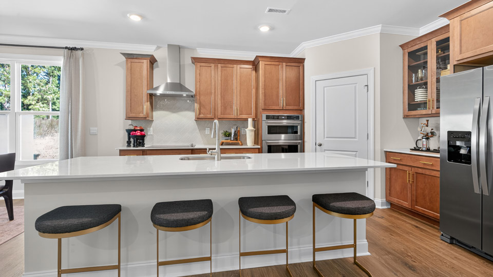 kitchen with quartz counters, kitchen island, pantry, stainless steel appliances