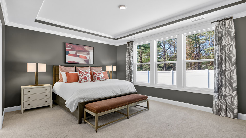 bedroom with tray ceiling and carpet flooring