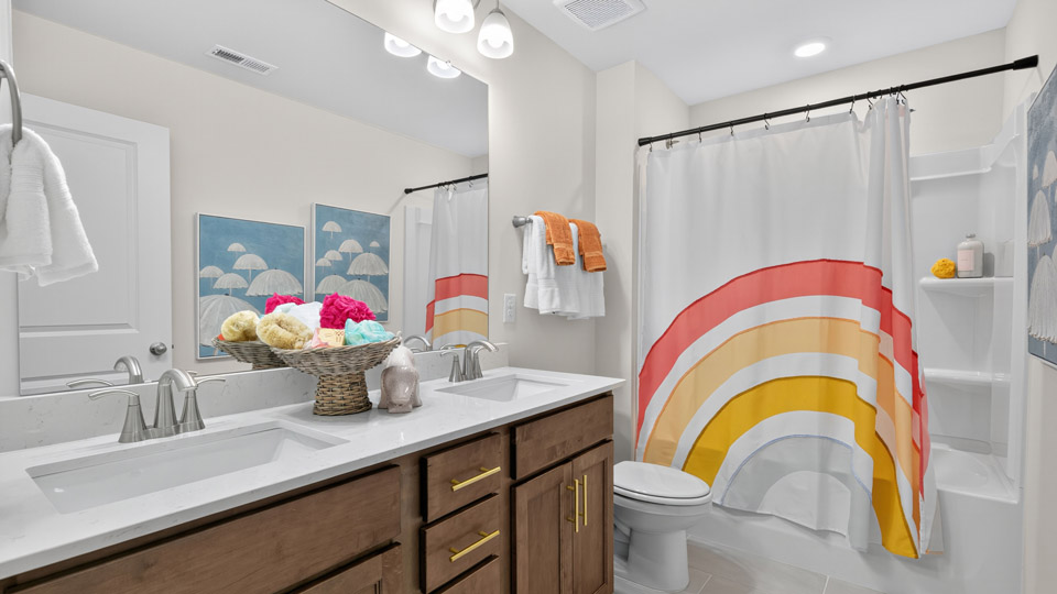 bathroom with brown cabinets quartz countertops and tub shower combo