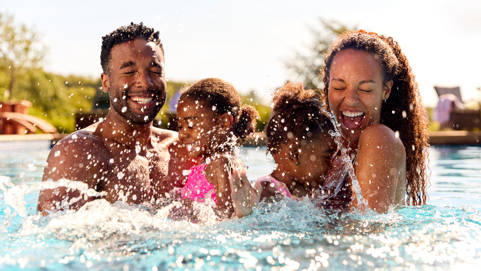 happy family splashing in pool