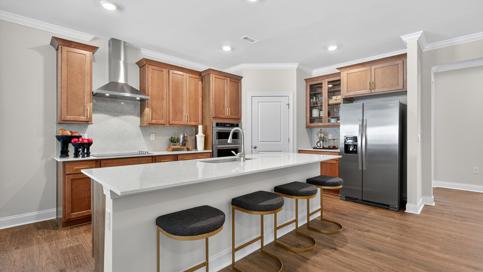 kitchen with brown cabinets quartz countertops ceramic tile backsplash and kitchen island