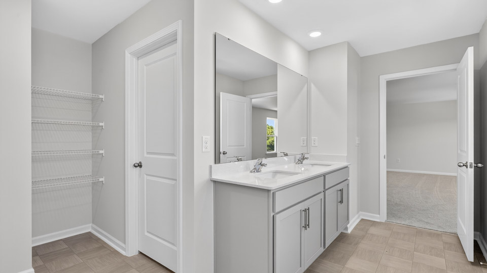 primary bathroom with walk in shower and dual vanity sinks
