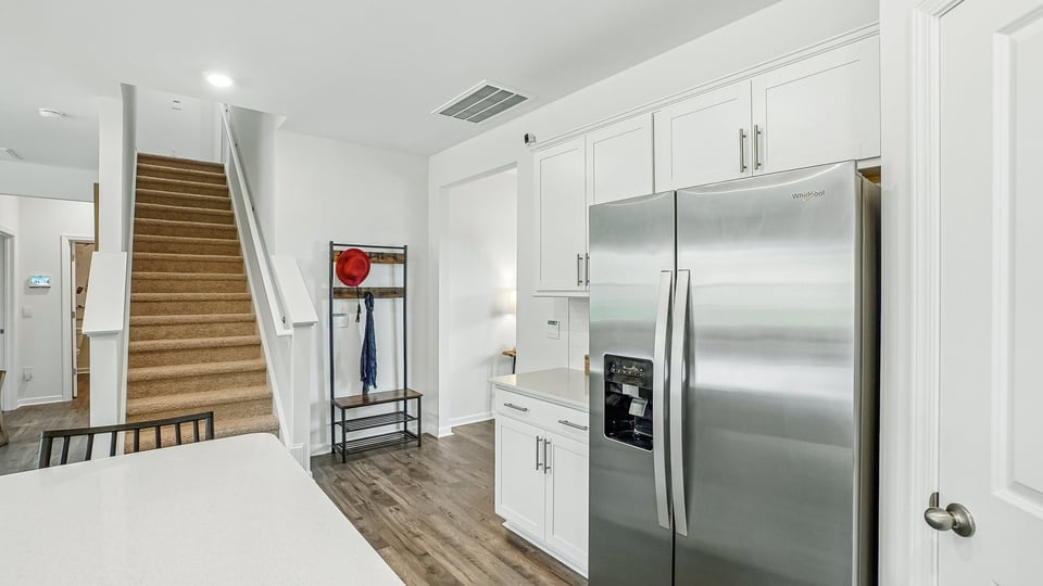 kitchen with quartz counters, kitchen island, pantry, stainless steel appliances