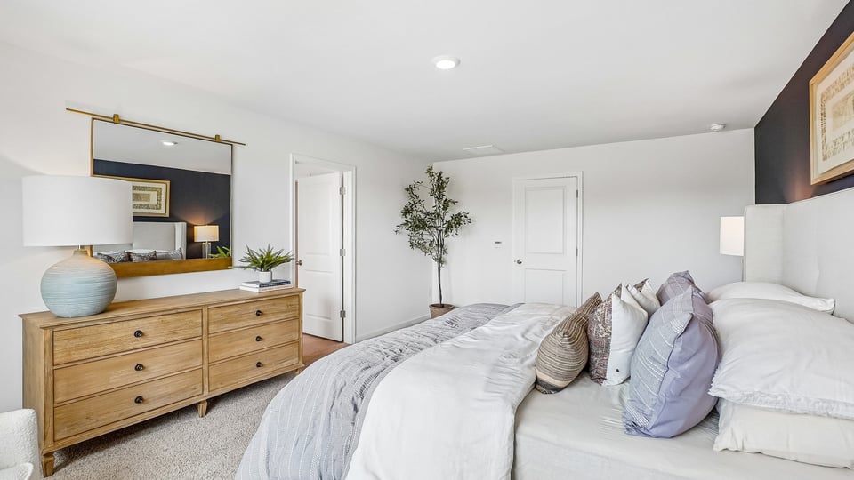 primary bedroom with two windows and carpeting, attached bath
