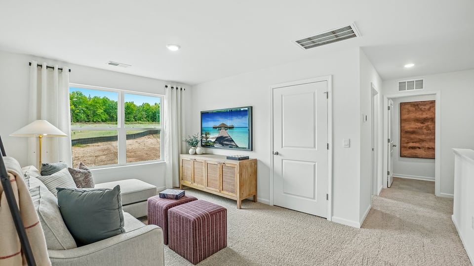 upstairs loft area with large windows and carpeting