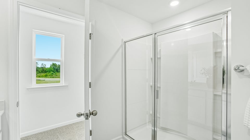 primary bathroom with walk in shower and dual vanity sinks