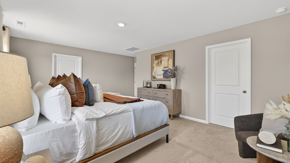 primary bedroom with two windows and carpeting, attached bath