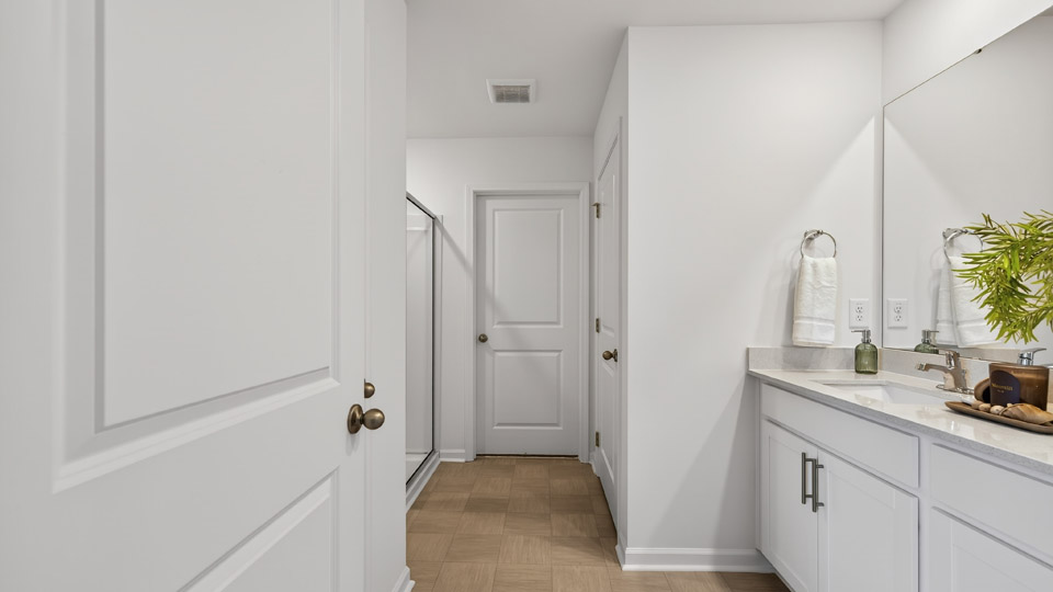 primary bathroom with walk in shower and dual vanity sinks
