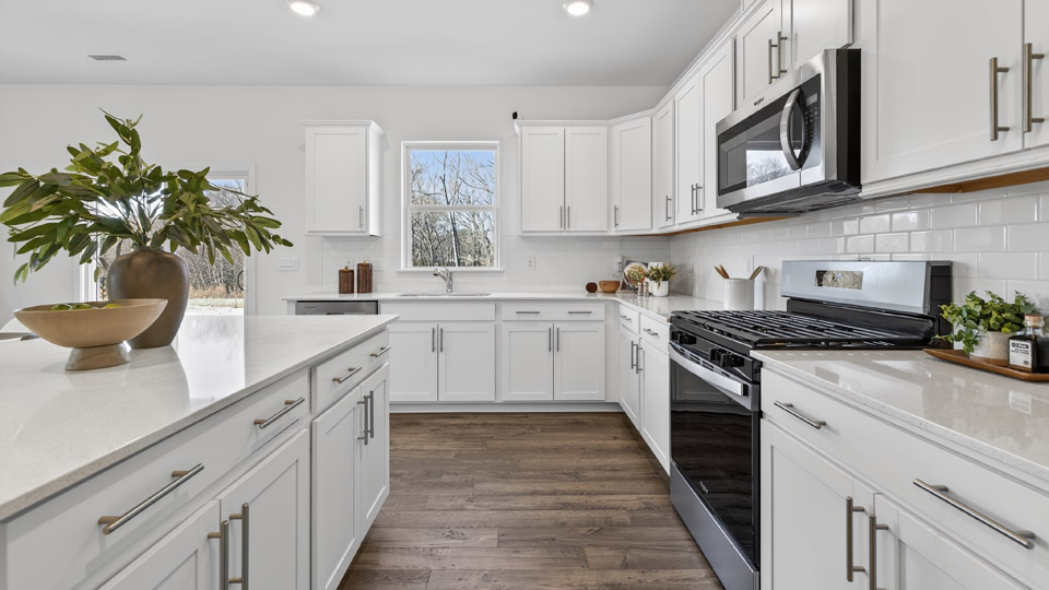 kitchen with quartz counters, kitchen island, pantry, stainless steel appliances