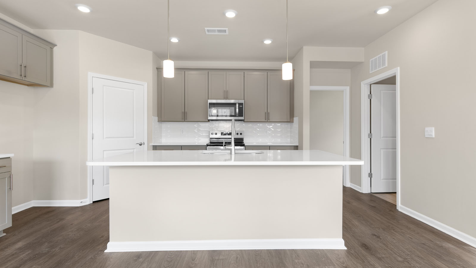 kitchen with quartz counters, kitchen island, pantry, stainless steel appliances