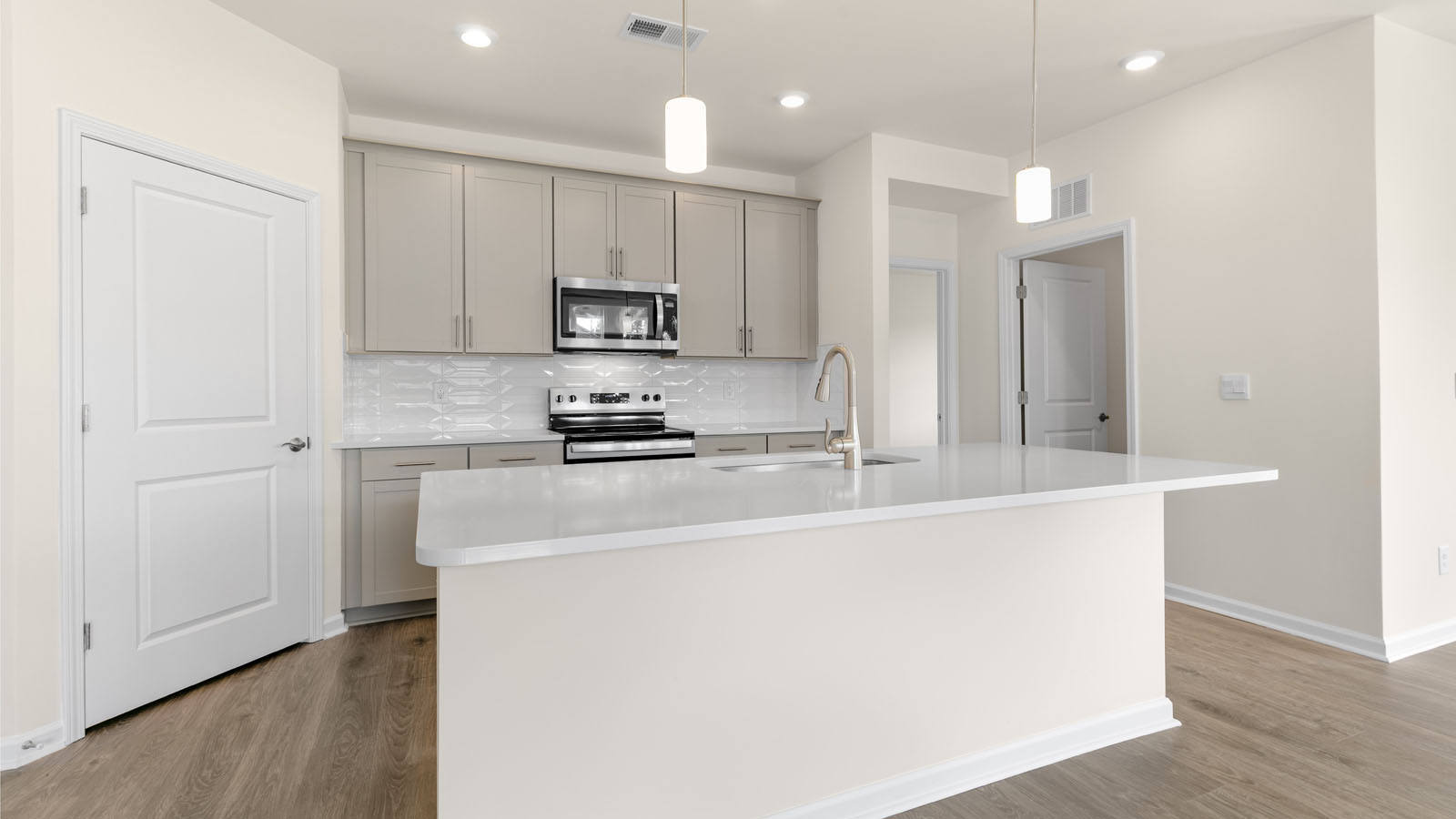 kitchen with quartz counters, kitchen island, pantry, stainless steel appliances