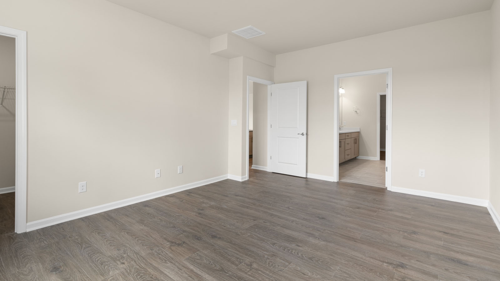 primary bedroom with two windows and revwood, attached bath