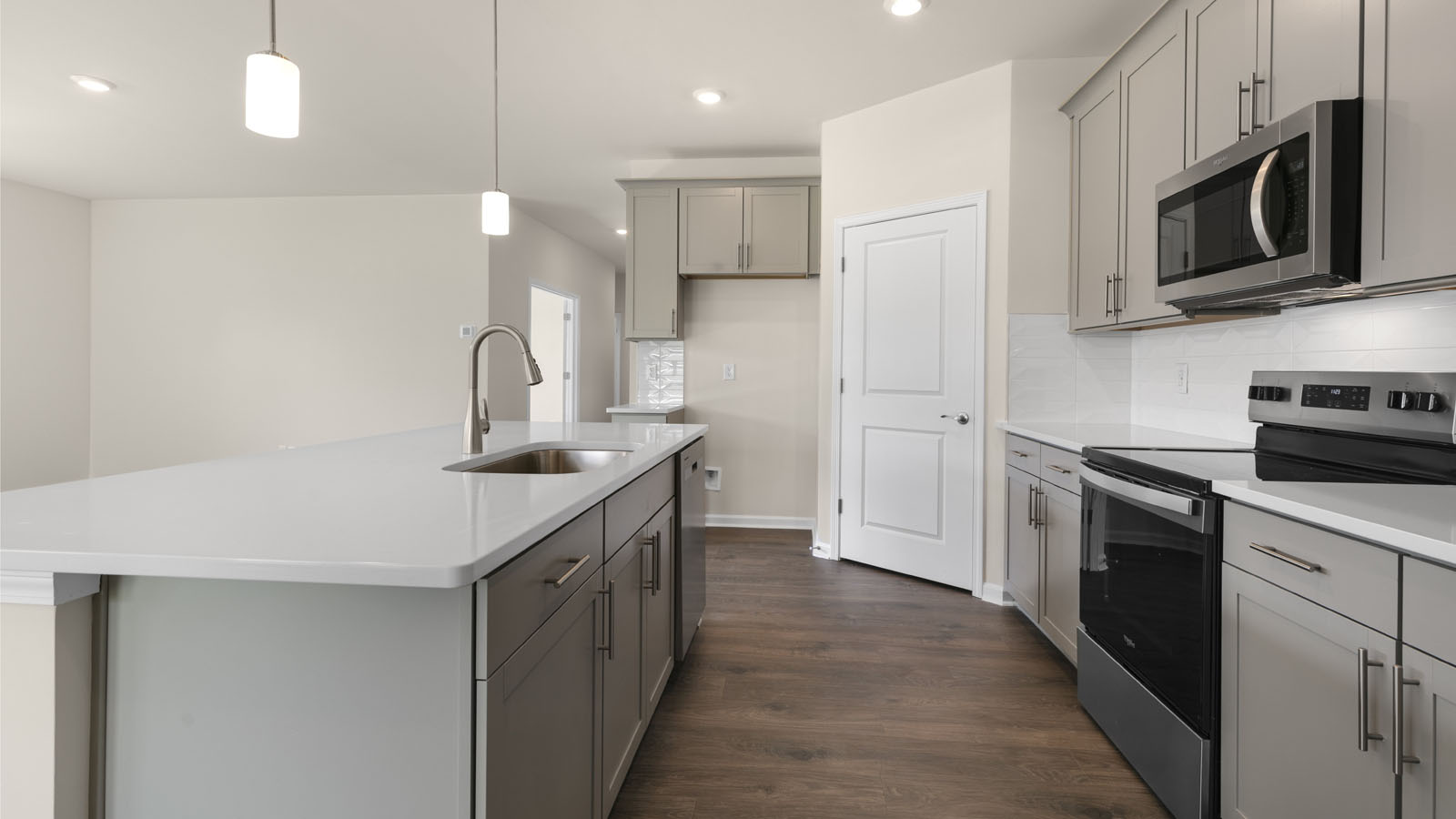 kitchen with quartz counters, kitchen island, pantry, stainless steel appliances